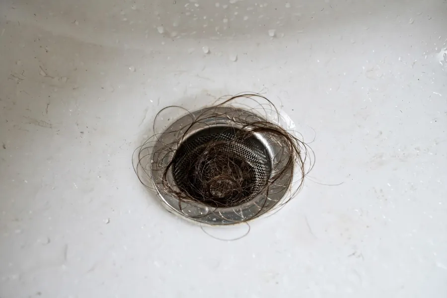 Drain strainer catching hair in a bathroom sink drain
