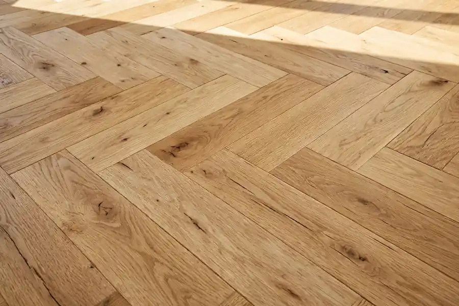 Close-up of a herringbone hardwood floor pattern with wide planks