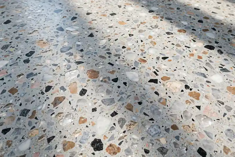 Polished terrazzo floor surface showing chips in cement